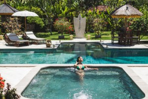 Woman in green swimsuit relaxing in outdoor jacuzzi with clean t